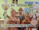 Дети фотографируются в декоративной рамке