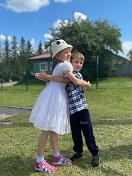 Девочка и мальчик играя обнимаются