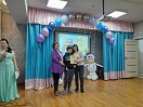 Девочке вручают диплом участника и подарочный сертификат
