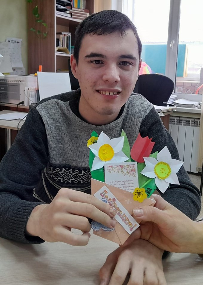 Мальчик держит созданный им бумажный букет цветов