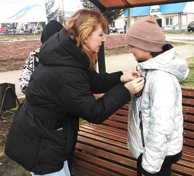 Першина Вероника Вячеславовна повязывает девушке Георгиевскую ленточку и листовку