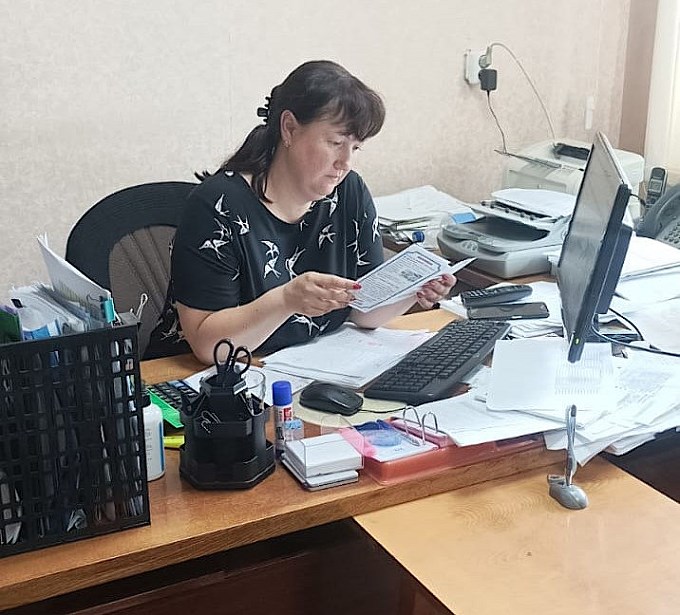 Женщина в офисе читает буклет