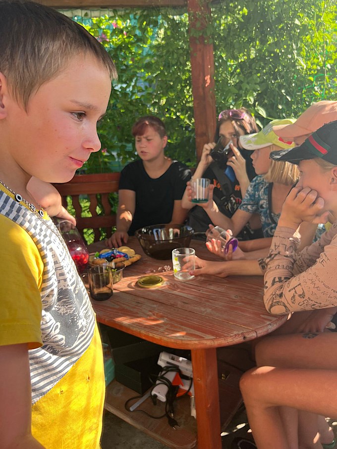Дети за столом пьют компот