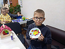 Мальчик держит в руках созданную им аппликацию