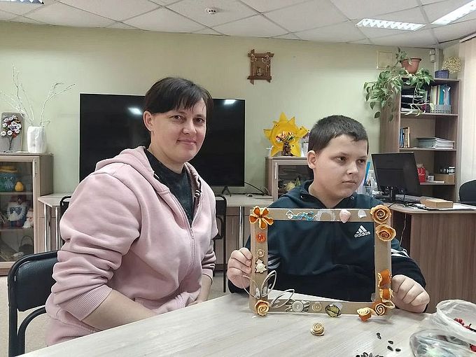Мама и сын показывают созданную ими фото-рамку