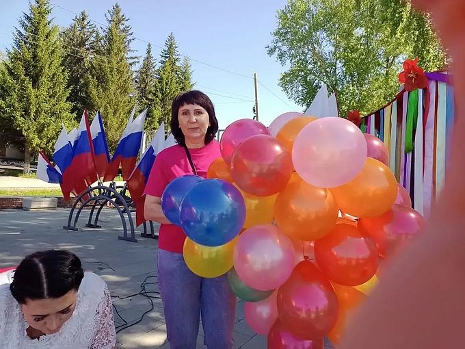 Заречнева Лариса Павловна держит связку воздушных шаров