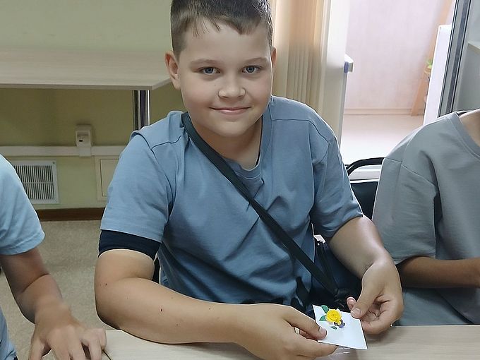 Мальчик показывает созданное им украшение