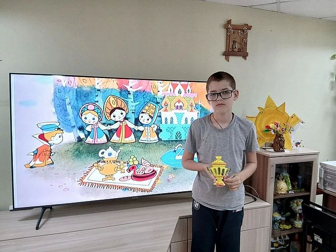 Мальчик показывает раскрашенную фигурку самовара