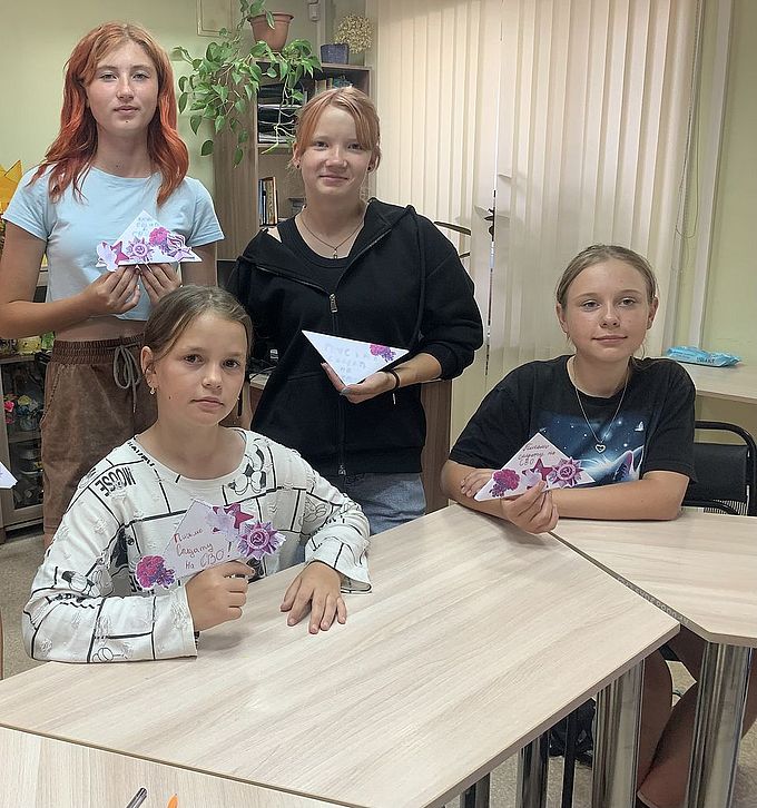 Четыре девочки-подростка держат в руках письма солдатам на СВО