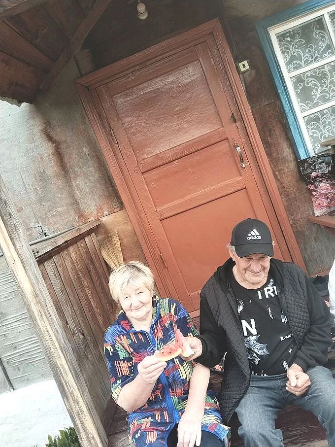 Пожилые женщина и мужчина едят арбуз