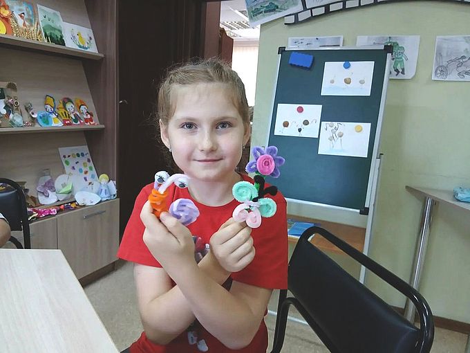 Девочка показывает созданные ею фигурки