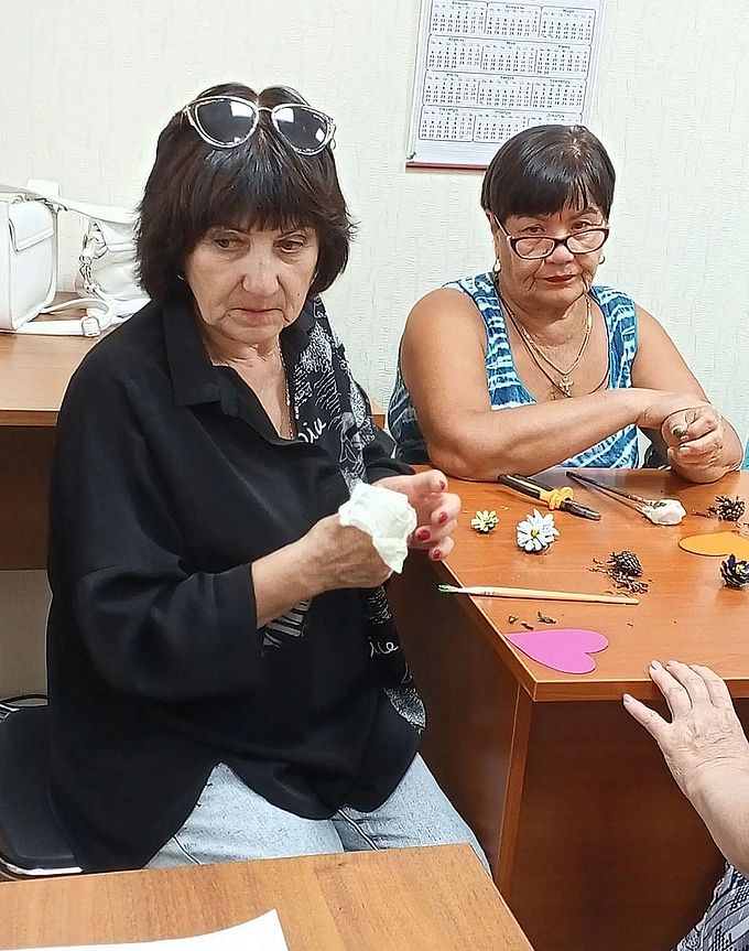 Пожилые женщины заняты изготовлением аппликаций из природных материалов