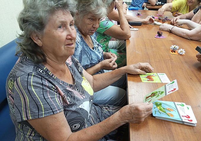 Пожилые женщины рассматривают карты-загадки