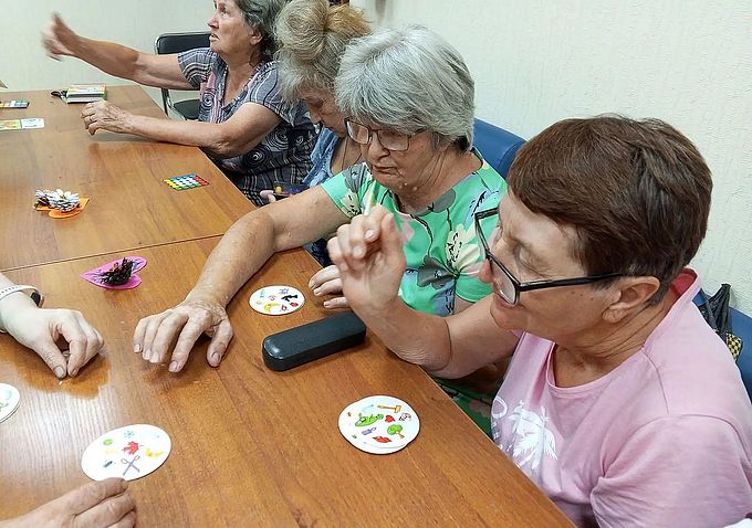 Пожилые женщины играют в настольную игру