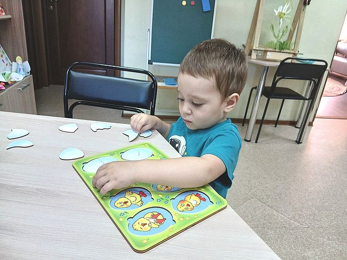 Мальчик работает с развивающей пазлом-вкладышем «Кто живёт в яйце?»