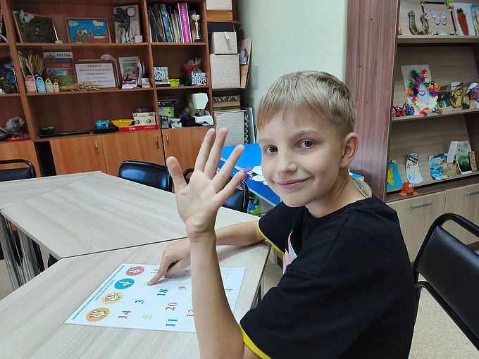 Мальчик показывает рукой число 5