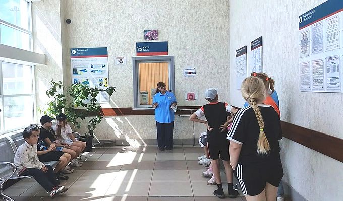 Дежурный по станции встречает посетителей в зале ожидания