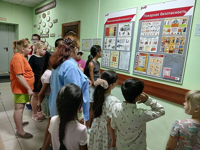 Участники экскурсии смотрят на плакаты транспортной и пожарной безопасности