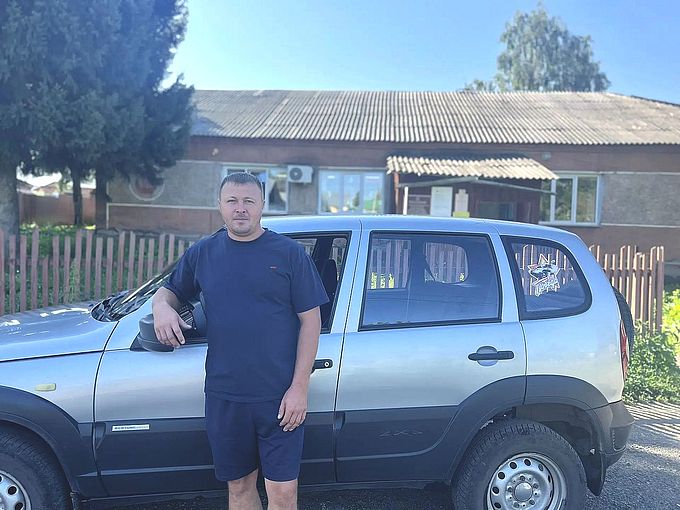 Водитель Дериглазов Александр Григорьевич рядом с автомобилем Chevrolet «Нива»