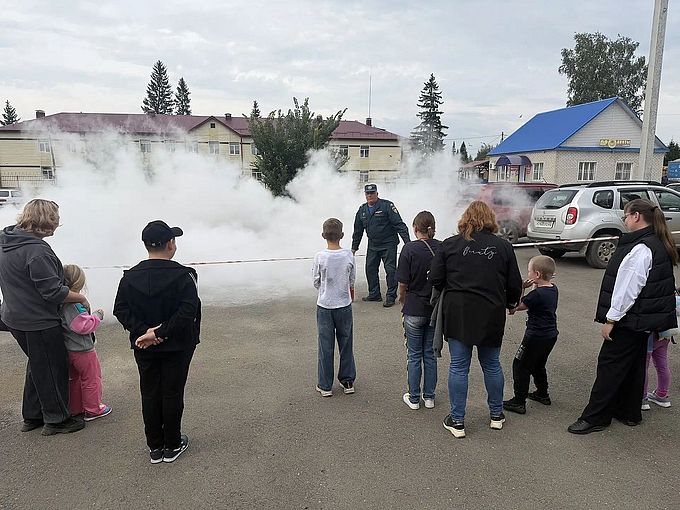 Дети и их родители смотрят на огнетушитель в действии