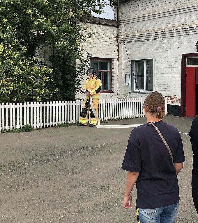 Пожарный в экипировке держит пожарный рукав