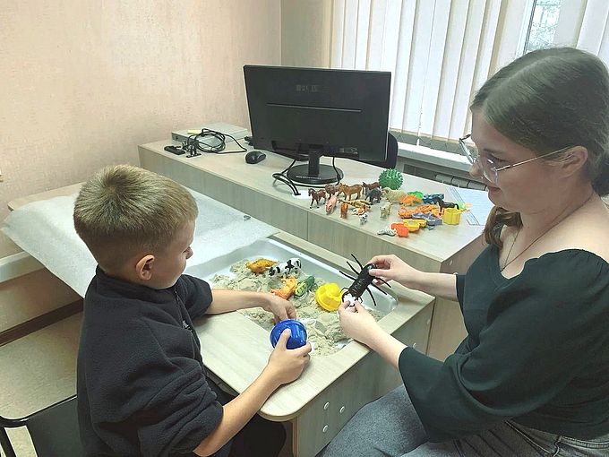 Наймушина Анастасия Александровна показывает мальчику фигурку жука